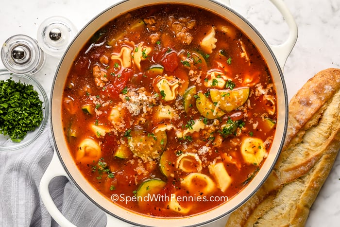 A kolbász Tortellini leves fűszeres, forró és ízletes. Friss zöldségekkel, olasz kolbásszal és sajttortellinivel megrakva ez a leves kiadós és tartalmas! #spendwithpennies #sausagetortellinisinisoup # leves # recept #italian # crockpot #instantpot #stovetop #lowcooker # sajt # cukkini Kolbász Tortellini leves egy edényben, kenyérrel az oldalán