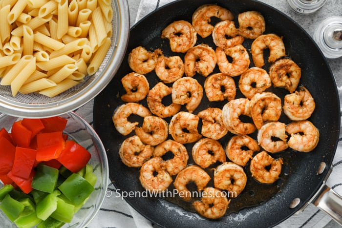 A Cajun garnélarák tészta egy nagyszerű hétvégi étkezés, amely egyszerű és finom. Fűszeres, garnélával és kolbásszal töltött, úgy fogja érezni magát, mintha New Orleans-ban lennél! #spendwithpennies #cajunshrimppasta #egy # recept # fűszeres # nyugodt # kenyérsütéssel # krémes # legjobb # paprikával # kenyérsütő főtt garnélarák az edényben, és tálak hozzávalói a Cajun garnélarák tészta elkészítéséhez