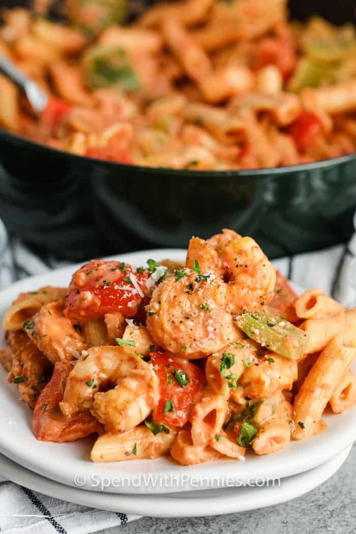 Finom, krémes, finom Cajun garnélarák tésztát kolbásszal és paprikával főznek. A fűszeres alfredo szósz mindenkit másodpercekre vágyik! #spendwithpennies #cajunshrimppasta #egy # recept # fűszeres # nyugodt # kenyérsütéses # krémes # legjobb #paprikával # kagylófazék galvanizált Cajun garnélarák tészta tele fazékkal a háttérben