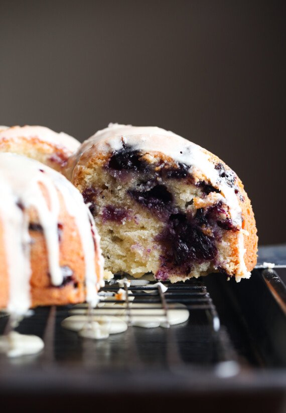 slicing a bundt cake with blueberries