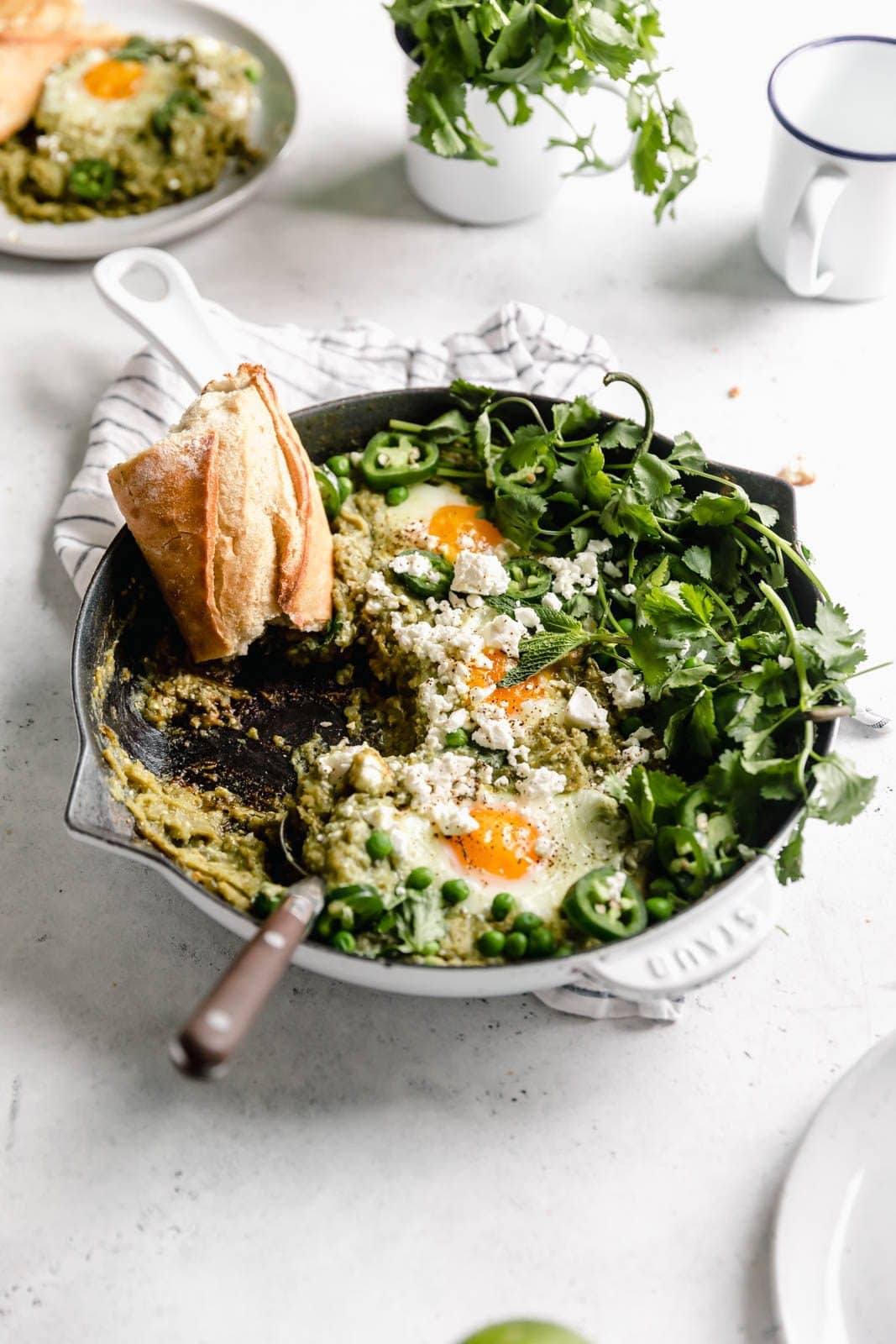 Zöld Shakshuka, más néven buggyantott tojás, fűszerezett zöld paradicsomszószban főzve, korianderrel és fetával.  Beszéljen az eddigi legjobb reggeliről!