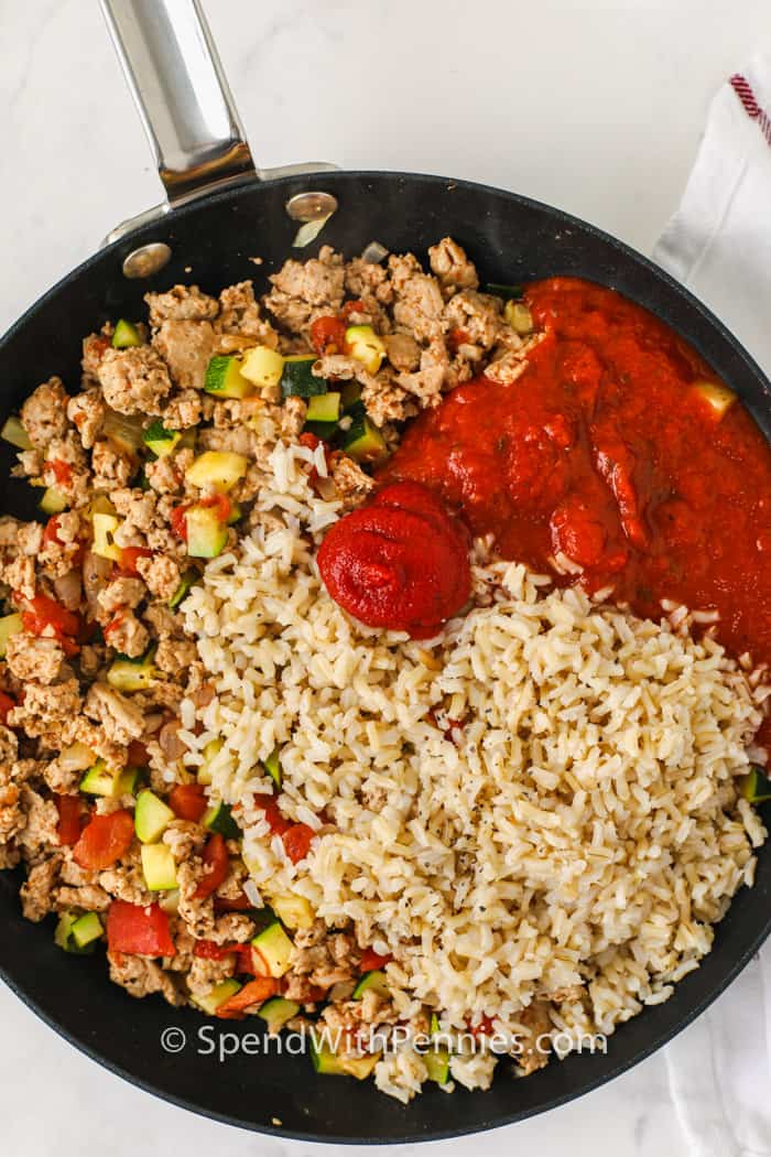 hozzávalókat adva az edénybe, hogy töltelék legyen az őrölt pulyka töltött paprikához