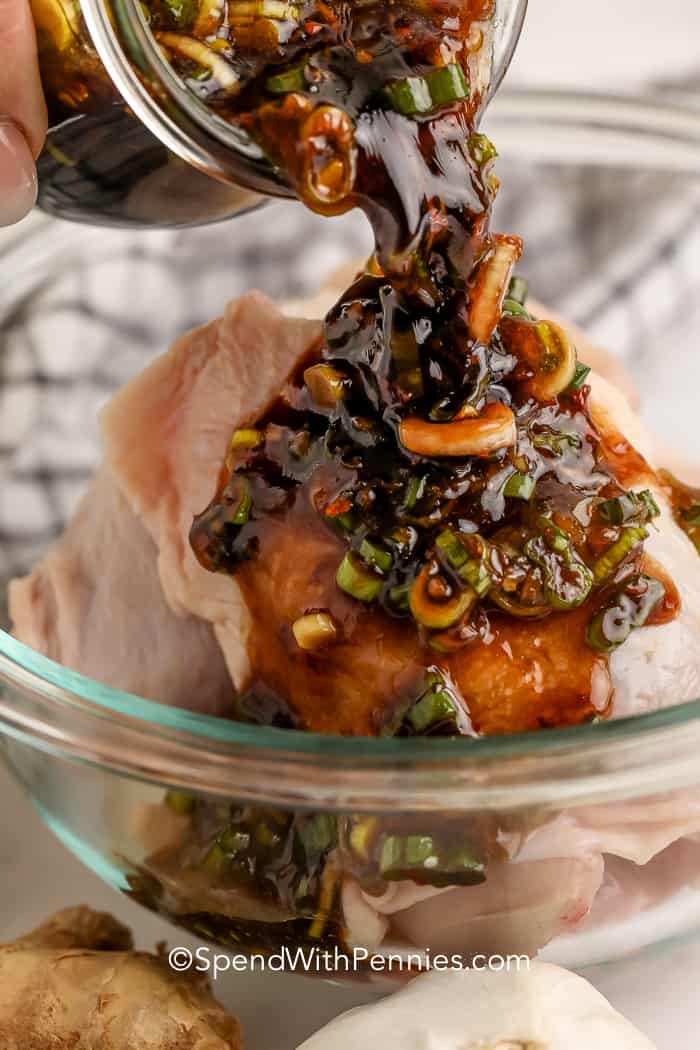 A gyömbéres szójapácot nyers csirkére öntik egy tálban