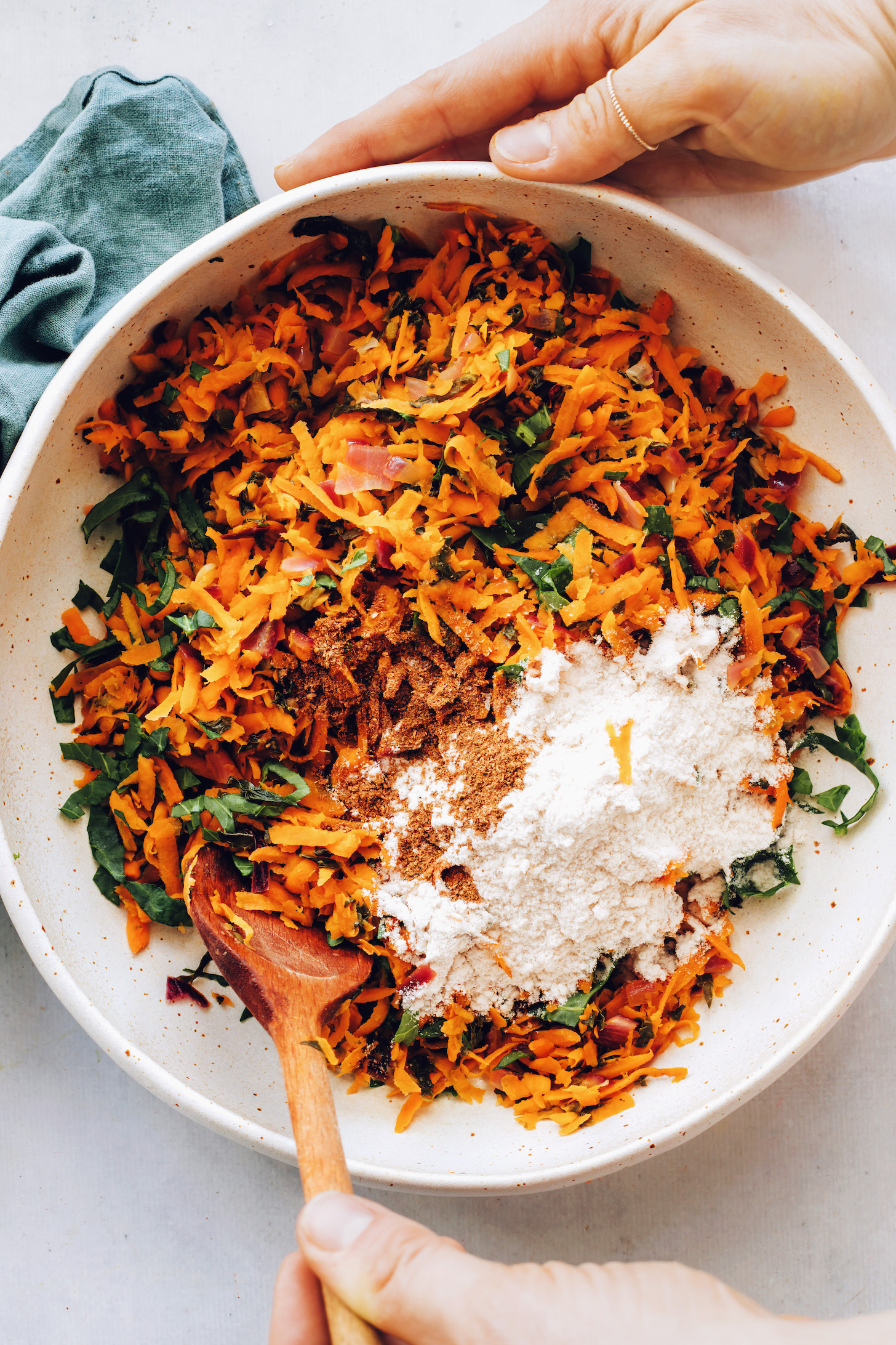 Tál aprított édesburgonyával, kelkáposzta, lilahagyma, só, garam masala és rizsliszt