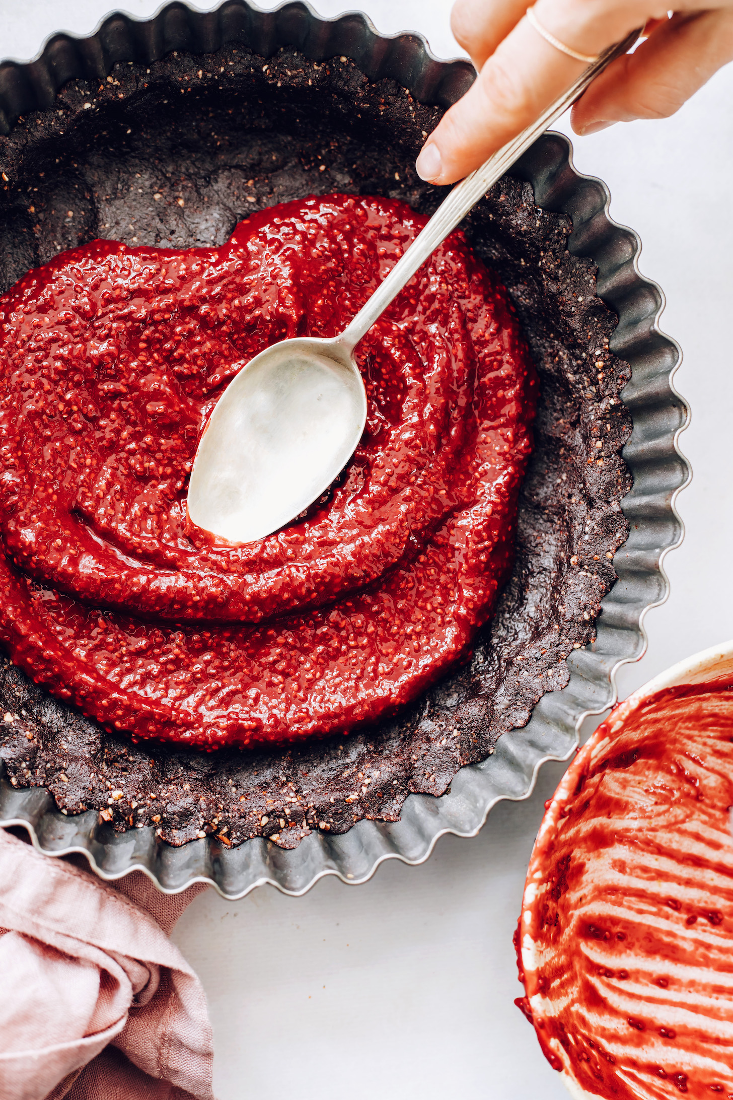 A málna tölteléket elosztva a csokoládé datolya kéregén