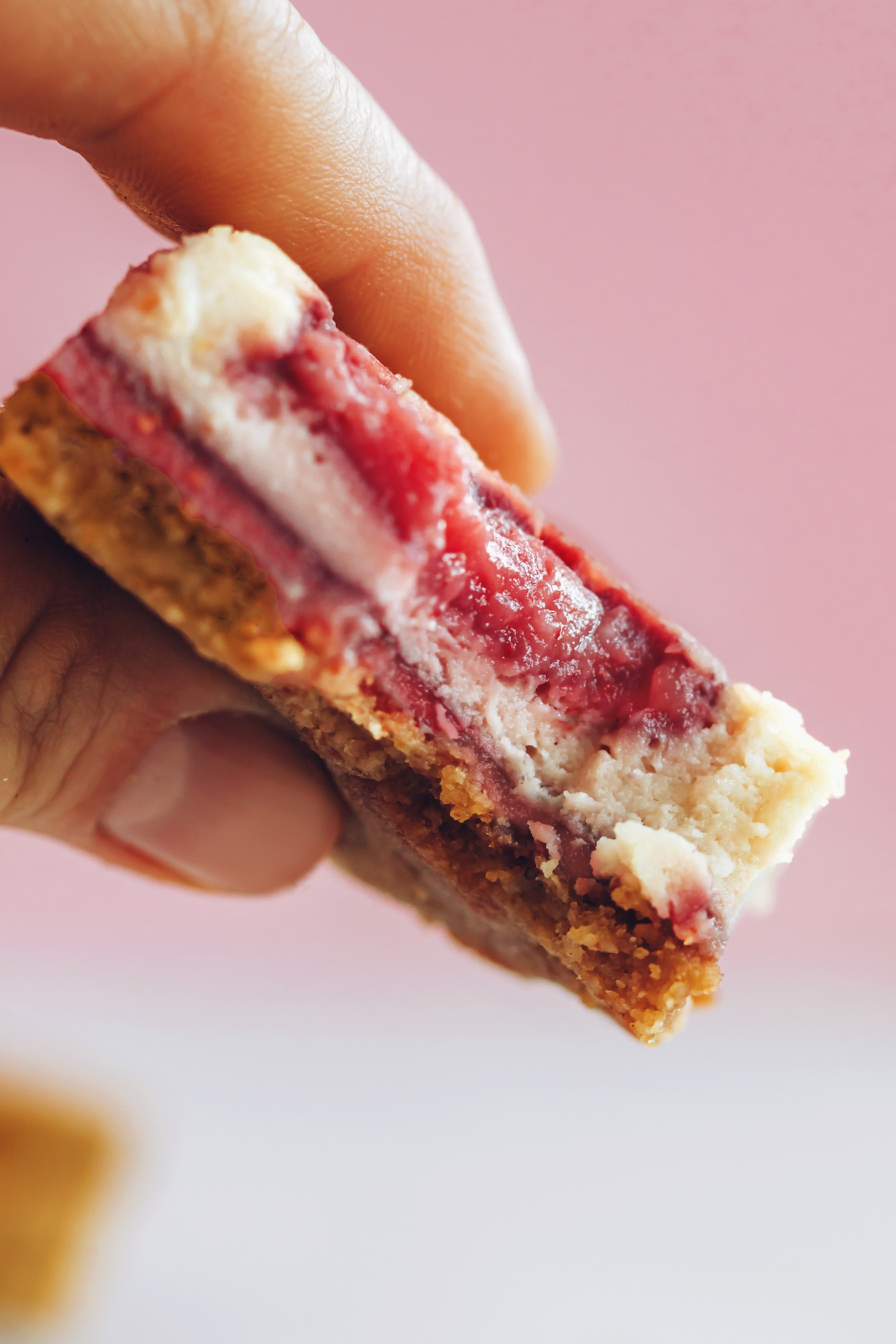 Egy eper sajttorta bár felemelve mutatja a textúrát