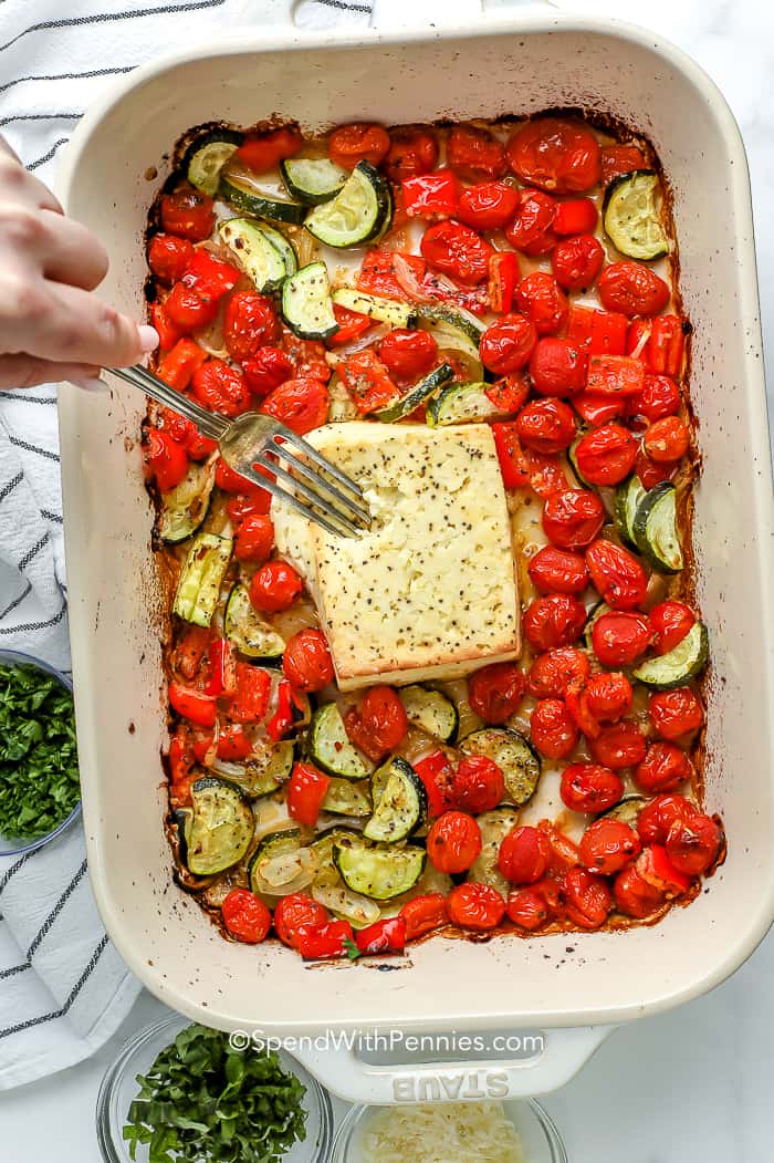 A sült vega Feta tészta tele van egészséges zöldségekkel és sós feta sajttal. Ez a gazdag és krémes tésztaétel tökéletes hús nélküli hétfőhöz! #spendwithpennies #fetapasta #fetapastarecipe #baked #tomato #tiktok #viral #creay #cherrytomato # easy #onepan #howtomake #oven #baked a sült feta keverése sült zöldségekkel