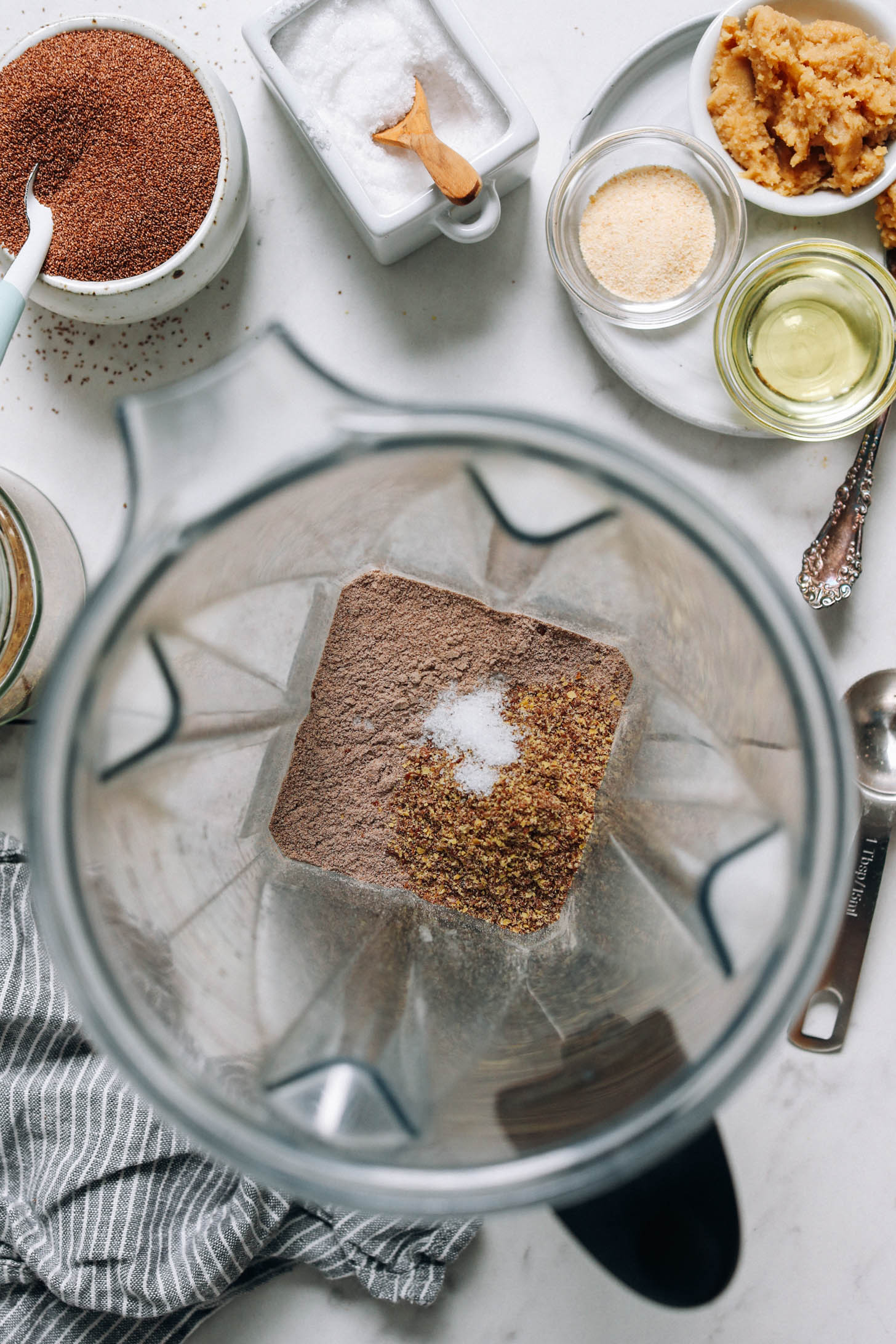 Teff lisztet, lenmaglisztet és sót turmixgépben