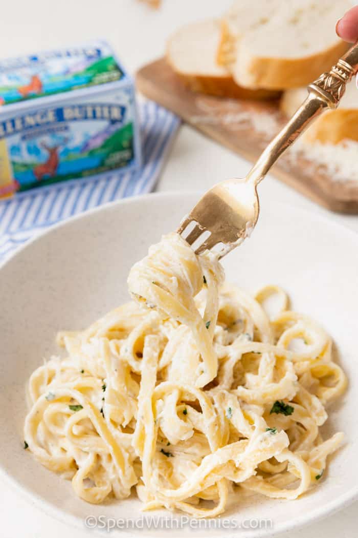 Fettuccine Alfredo egy tányéron villával