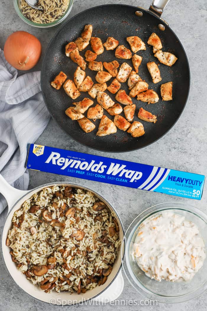 cooking chicken with other ingredients in bowls mixed and Reynolds wrap to make Chicken and Wild Rice Casserole