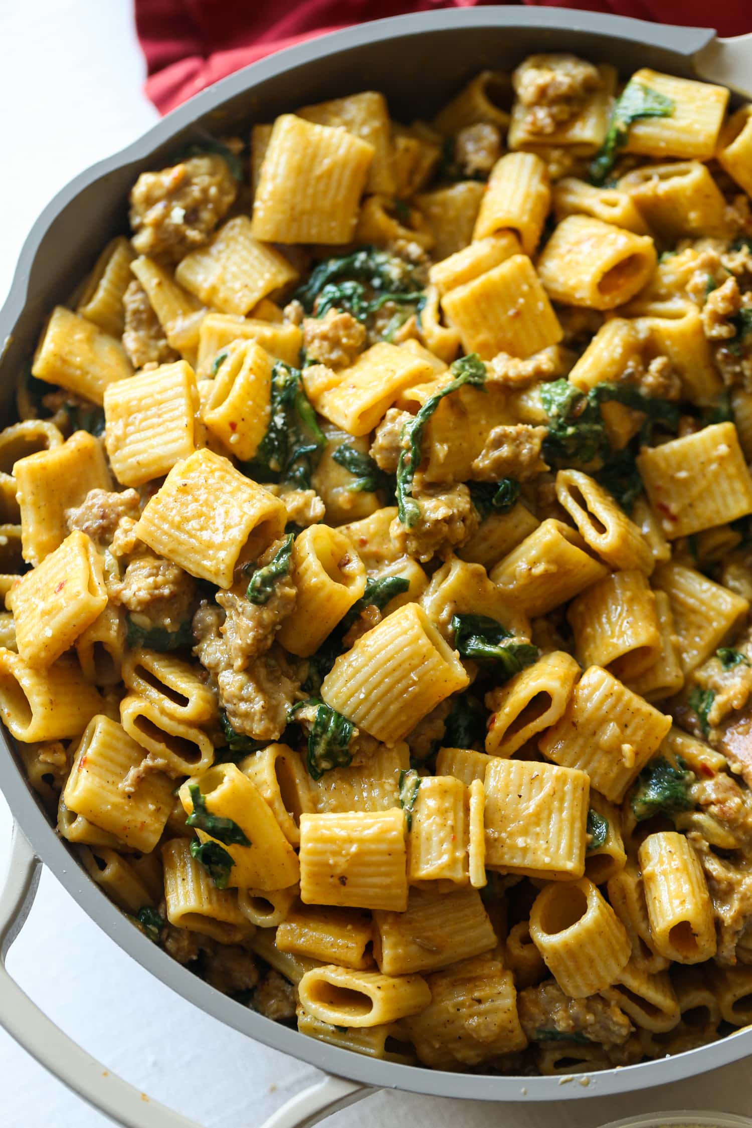 Noodles with sausage and spinach in a pumpkin cream sauce.