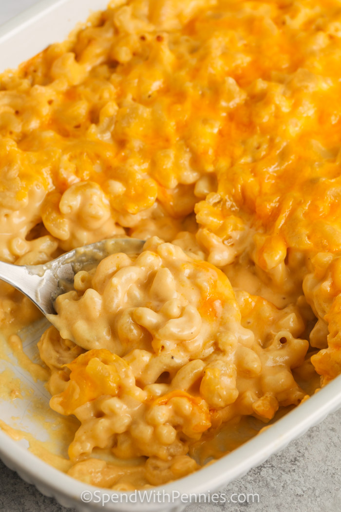taking a spoonful of Homemade Mac and Cheese Casserole out of the dish