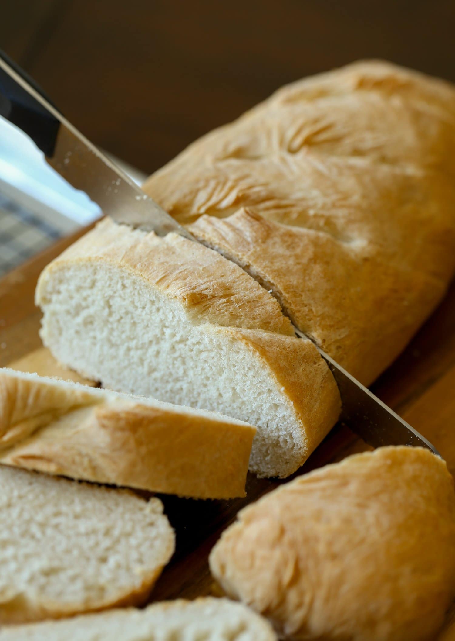 A loaf of French bread being sliced.