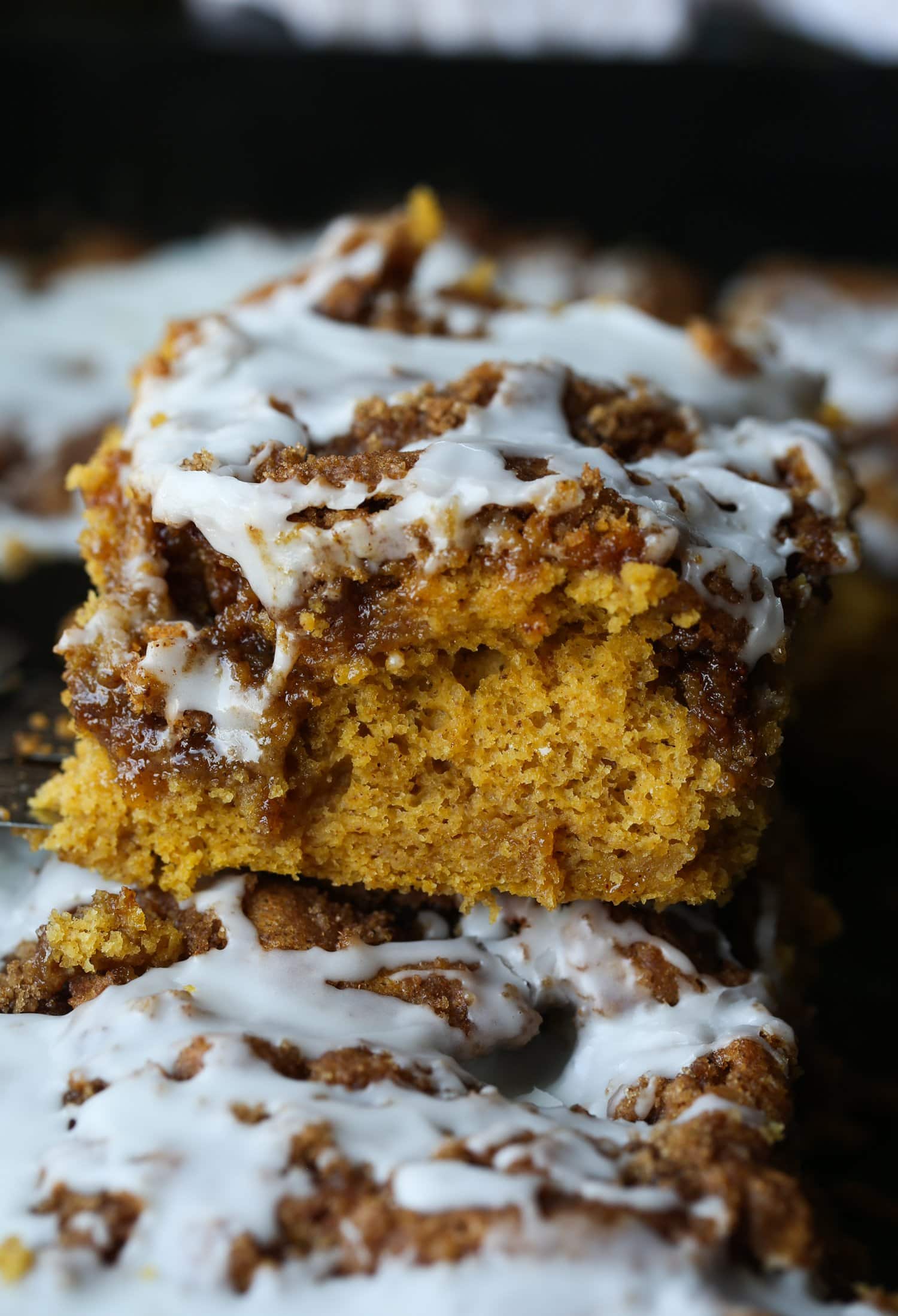 a slice of pumpkin cinnamon roll cake from a 9x13 pan