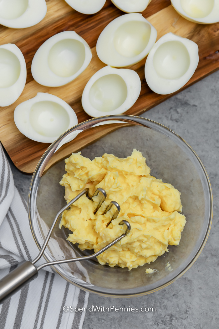mashing egg yolk to make Classic Deviled Eggs
